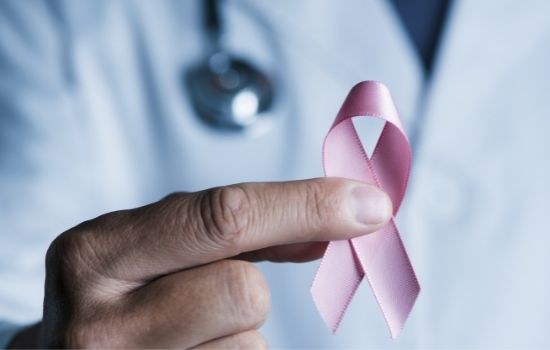 breast cancer doctor holding a pink awareness ribbon for breast cancer treatment advances